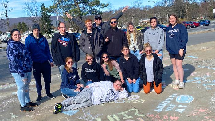 我们是 朋友 members Chalk the Walk at Penn State 阿尔图纳.